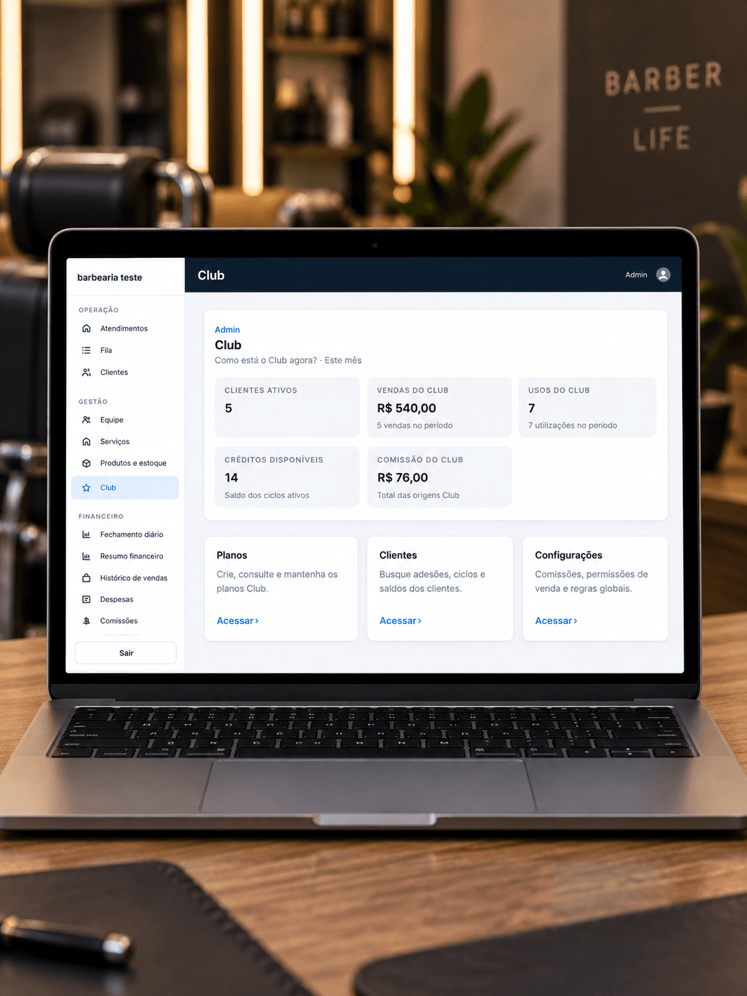 MacBook em uma barbearia mostrando a tela Club com planos, clientes, créditos, vendas e comissão